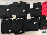 plusieurs paires de pantalons de survêtement Nike noirs et rouges et un sweat à capuche rouge