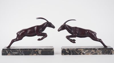 deux statues de béliers en train de courir, posées sur des socles en marbre, sur fond blanc