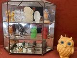 une vitrine en verre à côté de laquelle se trouve une petite figurine de hibou