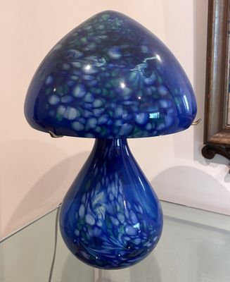 une table en verre sur laquelle est posée une lampe bleue