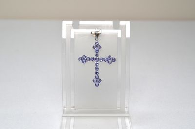 purple crystal cross pendant in clear acrylic display case