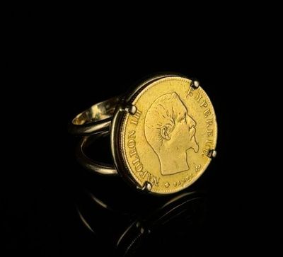 a close up of a gold coin ring on a black surface