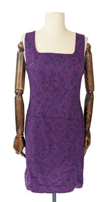le mannequin tient une robe violette sur un support pour mannequin
