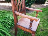 a wooden chair that is sitting in the grass