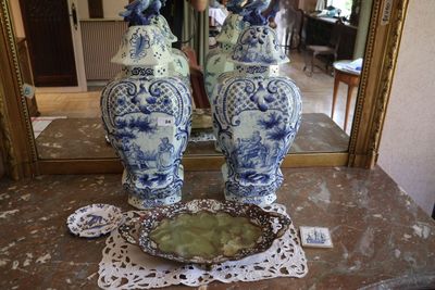 deux vases bleus et blancs posés sur une table devant un miroir