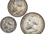 trois types différents de pièces d'argent représentant le visage et la barbe d'un homme