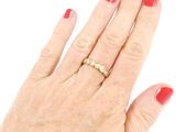 an image of a woman ' s hand with a red manicure and a gold ring