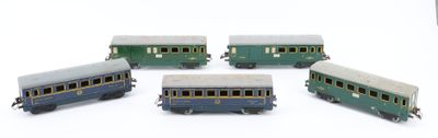 five toy trains on a white surface one is blue and the other is green