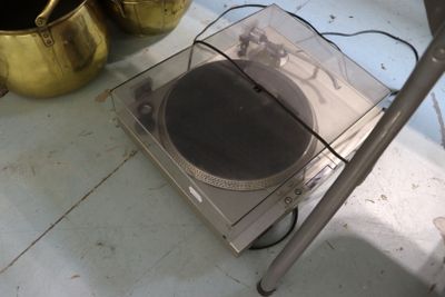 une platine posée sur une table, à côté d'un vase doré