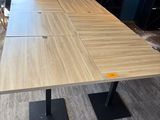 une table en bois avec quatre chaises noires dans une pièce