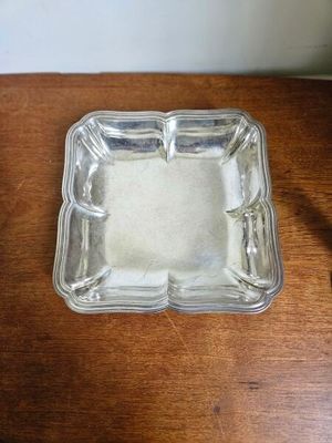 un petit cendrier en verre posé sur une table en bois