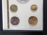 four different coins in a display case on a table