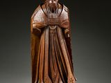 une statue en bois représentant un homme coiffé d'un chapeau et vêtu d'une robe