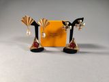 two pairs of earrings with pearls and a box on a table