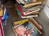 a pile of books sitting on the floor next to a pile of books