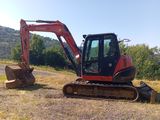 une petite pelleteuse qui est garée dans l'herbe