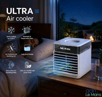 an air cooler sitting on top of a bed next to a lamp