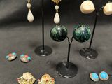 several pairs of earrings are displayed on a black surface