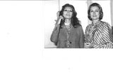 a black and white photo of two women talking on the phone