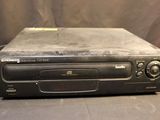 an old cd player sitting on top of a table next to a wall