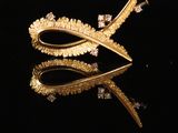 un gros plan sur une paire de boucles d'oreilles en or posées sur une surface noire