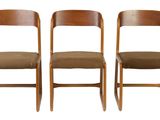 three wooden chairs sitting next to each other on a white surface