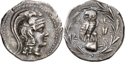a silver coin with an image of a woman and an owl on it