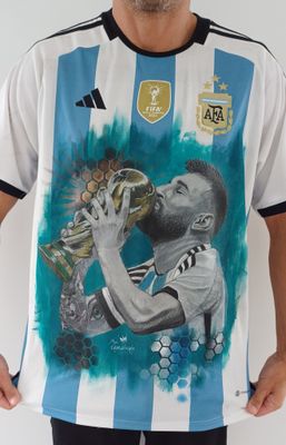 un footballeur tenant un trophée devant un mur blanc