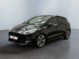 une Ford Fiesta noire garée dans une pièce blanche