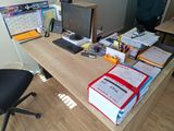 a desk with a computer, books, and other office supplies on it