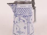 une cafetière bleue et blanche posée sur une table blanche