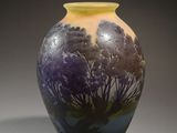 a vase with a painting on it sitting on a table