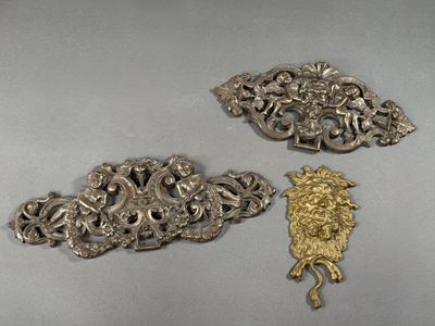 three antique silver metal brooches on a gray surface