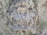a stone carving of a face on the side of a building