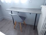 a desk with a chair and a radiator in the corner