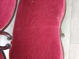 two red chairs and a table in a room with wood flooring