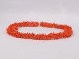 a close up of an orange beaded necklace on a white background