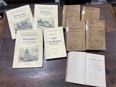 several old books are sitting on a wooden table next to an open book