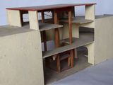 a doll house with a desk and shelves in it