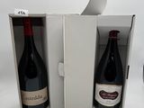 deux bouteilles de vin dans un carton posé sur la table