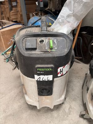 a machine that is sitting on the ground next to a pile of boxes