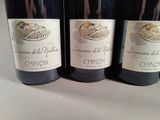 three bottles of wine are lined up on a table