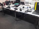 un bureau sur lequel se trouvent un ordinateur portable, un écran et d'autres appareils électroniques