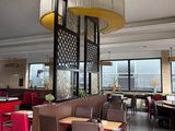 tables and chairs in a restaurant with a view of the city