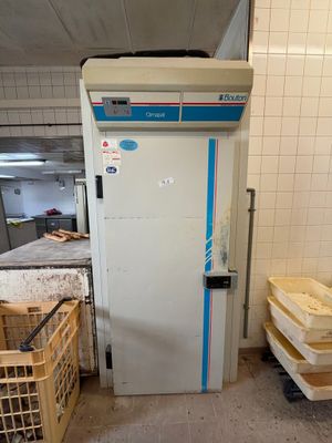 une photo d'une cuisine avec un réfrigérateur et des caisses