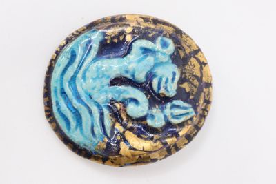 an image of a blue and gold button with a dragon on it
