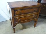 une petite commode en bois dans un coin de la pièce