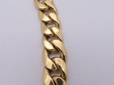 a close up of a gold chain bracelet on a white surface
