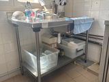 a kitchen with a stainless steel work table and a sink