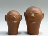two clay heads sitting next to each other on a table